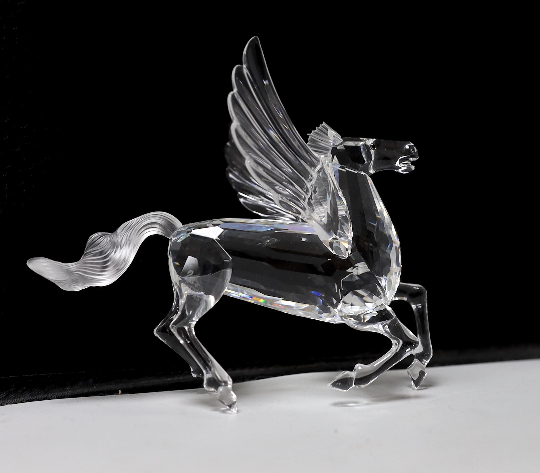 Three Swarovski Crystal figures comprising Pegasus, unicorn and dragon, each with boxes and booklets, the largest 15cm wide